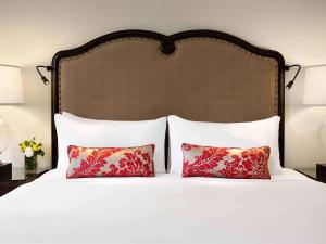 路易斯湖路易斯湖费尔蒙酒店的一张带两个枕头的床和一个大床头板