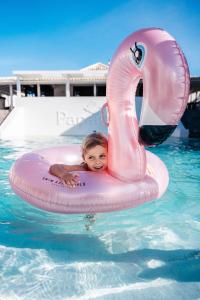 威廉斯塔德鹦鹉海滩度假酒店的游泳池里的木筏上的小孩