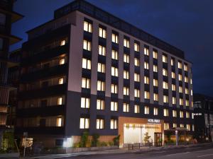 京都HOTEL ABEST GRANDE KYOTO KIYOMIZU的夜间有灯光窗户的办公楼