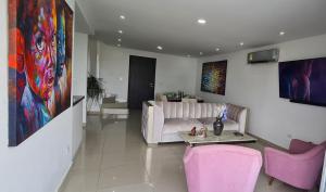 巴兰基亚Espectacular Penthouse dúplex bien equipado的客厅配有白色沙发和粉红色椅子