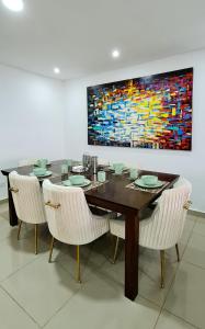 巴兰基亚Espectacular Penthouse dúplex bien equipado的一间带桌椅和绘画的用餐室
