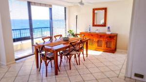 黄金海岸鹈鹕金沙海滩度假村的一间带桌椅的用餐室和一个阳台