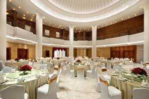 成都成都总府皇冠假日酒店的一个带白色桌椅的大型宴会厅