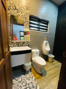 卢塞纳Sto Niño Residences Lucena City的一间带卫生间、水槽和镜子的浴室