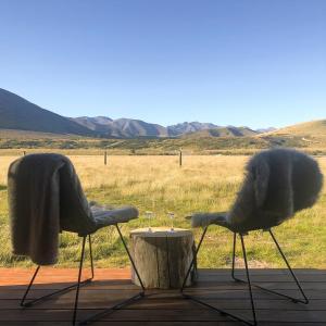 特威泽尔Peak View Cabin - Ben Ohau - Stylish Seclusion的两把椅子坐在桌子旁,配酒杯