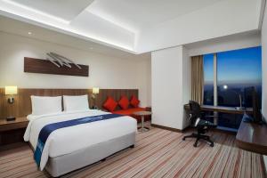 雅加达雅加达东荟城智选假日酒店的酒店客房配有一张床、一张书桌和一台电视。