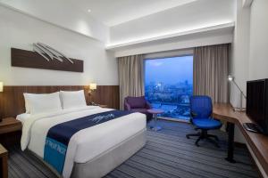 雅加达雅加达东荟城智选假日酒店的配有一张床、一张书桌和一扇窗户的酒店客房