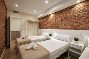 巴塞罗那BBarcelona Sagrada Familia Flats的一间卧室设有两张床和砖墙