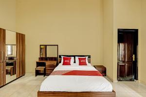SeturanOYO 91522 Candi Gebang Guesthouse的一间卧室配有一张带红色枕头的大床