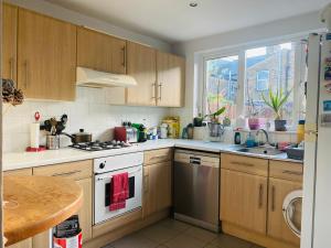 伦敦A lovely guest room in West London的厨房配有木制橱柜和白色炉灶烤箱。