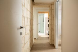 莱切DonCarlo Suite Relais - Free Parking-parcheggio gratuito的走廊设有白色的墙壁和木地板