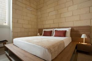 莱切DonCarlo Suite Relais - Free Parking-parcheggio gratuito的卧室配有一张带两个红色枕头的大型白色床