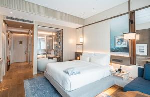 上海上海阿纳迪酒店（开启身心灵的唤活疗愈之旅）的卧室配有一张白色大床和一张蓝色沙发。