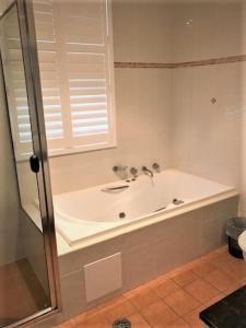 坦卡里Sunrise Luxury Apartments的带浴缸和窗户的浴室