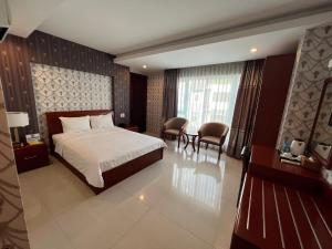 胡志明市Nam Hy 1 Hotel的酒店客房带一张床、一张桌子和椅子