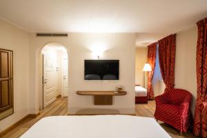 博尔米奥巴格尼威池酒店的配有一张床和一把椅子的酒店客房