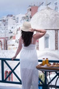 费拉DELION VIEW HOTEL的阳台上穿着白色衣服和帽子的女人
