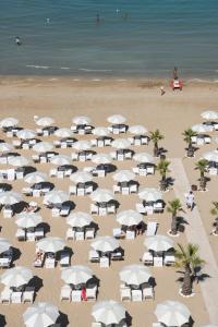 佩萨罗伊克斯西尔酒店的享有海滩上方的白色遮阳伞美景