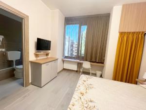 蒙扎Sissi Comfort Rooms Foresteria Lombarda的酒店客房设有一间带一张床和电视的卧室