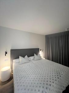 安道尔城Apartaments Turístics Conseller的卧室配有一张带白色棉被的大床