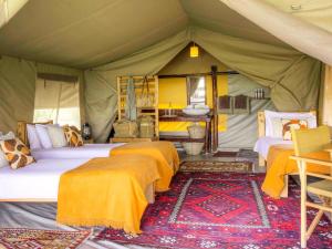 Musiara CampsiteKandili Camp的帐篷内一间卧室,配有四张床