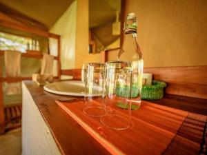 Musiara CampsiteKandili Camp的一组酒杯坐在柜台上,装有一瓶酒