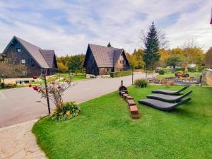 普利特维采湖Plitvice Luxury Etno Garden的草地上有一排长椅的院子