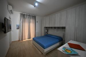 卡利亚里eliterooms的一间卧室配有一张蓝色的床和一张桌子