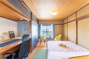 小田原市汐の香 - shio no kaori的小房间设有一张床、一张桌子和椅子