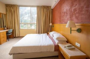海法马姆海酒店的一间卧室配有一张床、一张书桌和一个窗户。