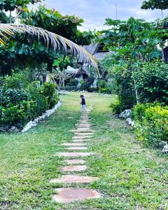 米查维Botanica Eco Lodge的走在草地上的小径上的孩子