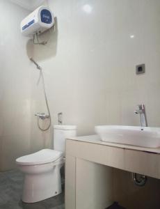 占碑市阿尔米拉民宿的浴室配有白色卫生间和盥洗盆。