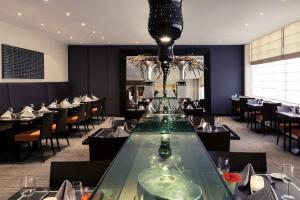 尼沃海恩尼沃海恩-乌特勒支弗莱彻酒店及餐厅的一间设有玻璃桌和椅子的用餐室