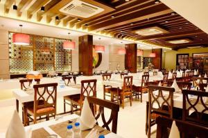 Kushinagar拘尸那迦帝国酒店的餐厅内带桌椅的用餐室