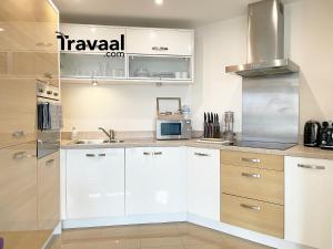 法恩伯勒Travaal.©om - 2 Bed Serviced Apartment Farnborough的厨房配有白色橱柜和微波炉