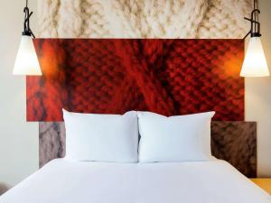 根特宜必思根特中心歌剧院酒店的一张带白色枕头和红色床头板的床