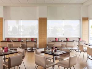 圣路易斯波托西宜必思圣路易斯波托西酒店的用餐室设有桌椅和窗户。