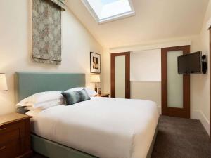 旧金山赫利塔兹普莱斯哥罗多利广场费尔蒙酒店的卧室配有白色的床和天窗
