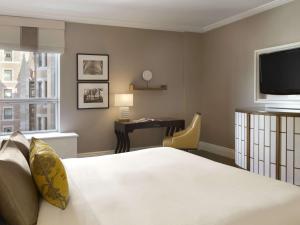 魁北克市费尔蒙特莱沙托夫隆特纳克酒店的酒店客房配有一张床、一张书桌和一台电视。