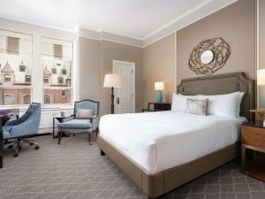 魁北克市费尔蒙特莱沙托夫隆特纳克酒店的一间卧室配有一张床、一张桌子和一把椅子