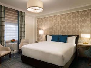 维多利亚费尔蒙特帝后大酒店的一间卧室配有一张带蓝色枕头的大床