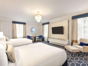 温哥华Fairmont Hotel Vancouver的酒店客房设有两张床和一台平面电视。