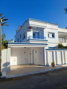 纳布勒Superbe étage de villa vue sur mer的前面有车库的白色房子
