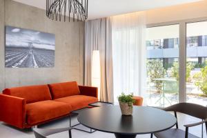 格雷乌莱班Villa Castellane的客厅配有橙色沙发和桌子