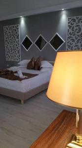 克拉约瓦鹤林机场酒店 - 克拉约瓦的一间卧室配有一张床和一盏灯及台灯