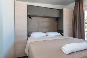 普利莫顿CAMP ADRIATIC MOBILE HOMES - PRIMOŠTEN的卧室配有带白色枕头的大床