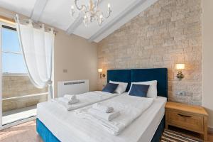 诺瓦瓦斯Villa Grivičić的一间卧室配有一张大床和蓝色床头板