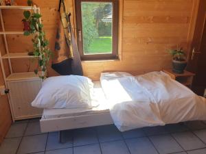 阿特尔高地区圣格奥尔根Homestay Sleepy Traveler的窗户客房内的一张带白色床单的床