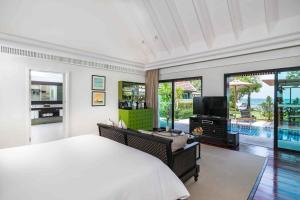 塔林甘海滩InterContinental Koh Samui Resort, an IHG Hotel的一间卧室配有一张大床和一台电视。