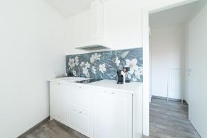 梅罗内LA CORTE SUL LAGO的白色的厨房设有水槽和花卉壁纸